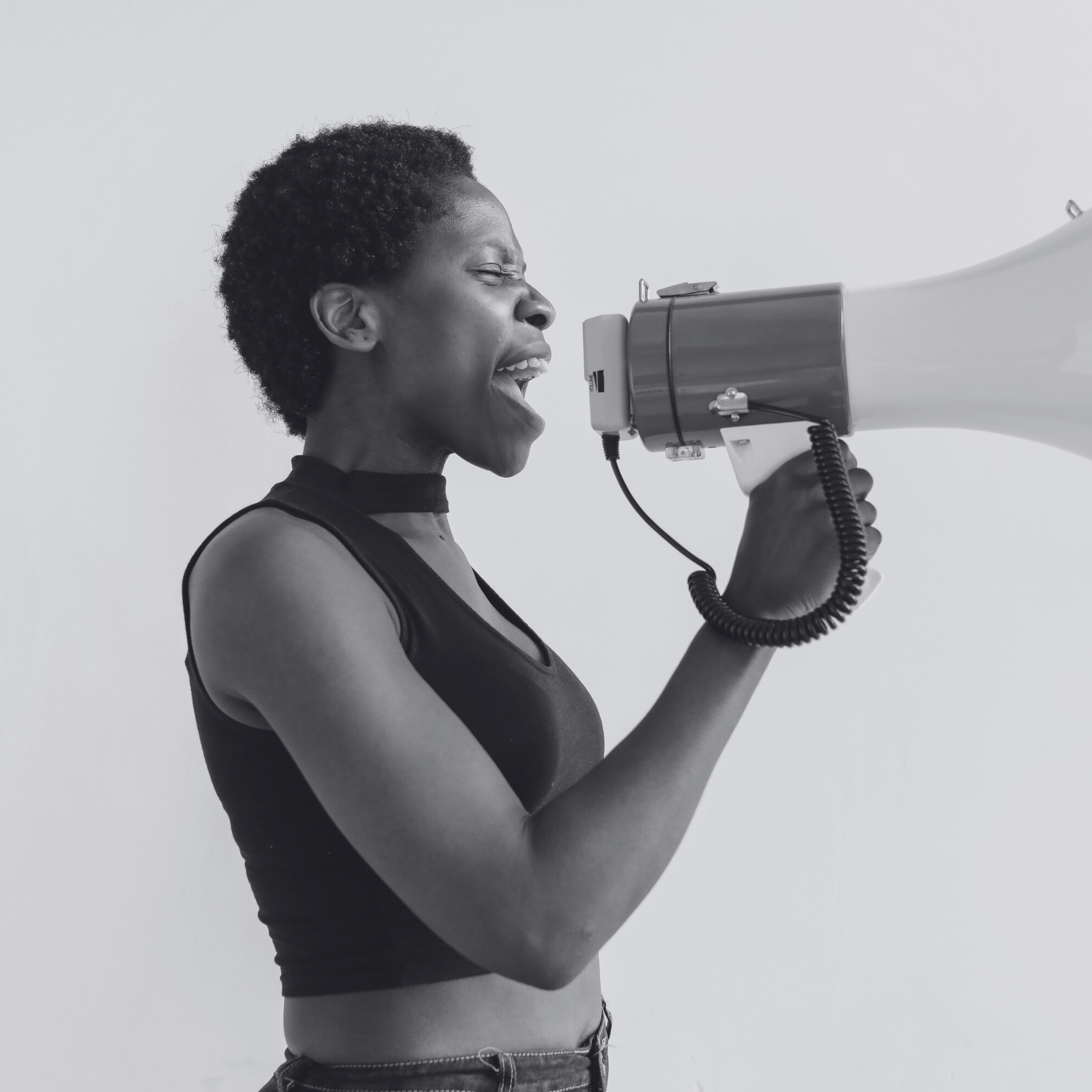 Black and white photo of a woman using a megaphone to speak out.